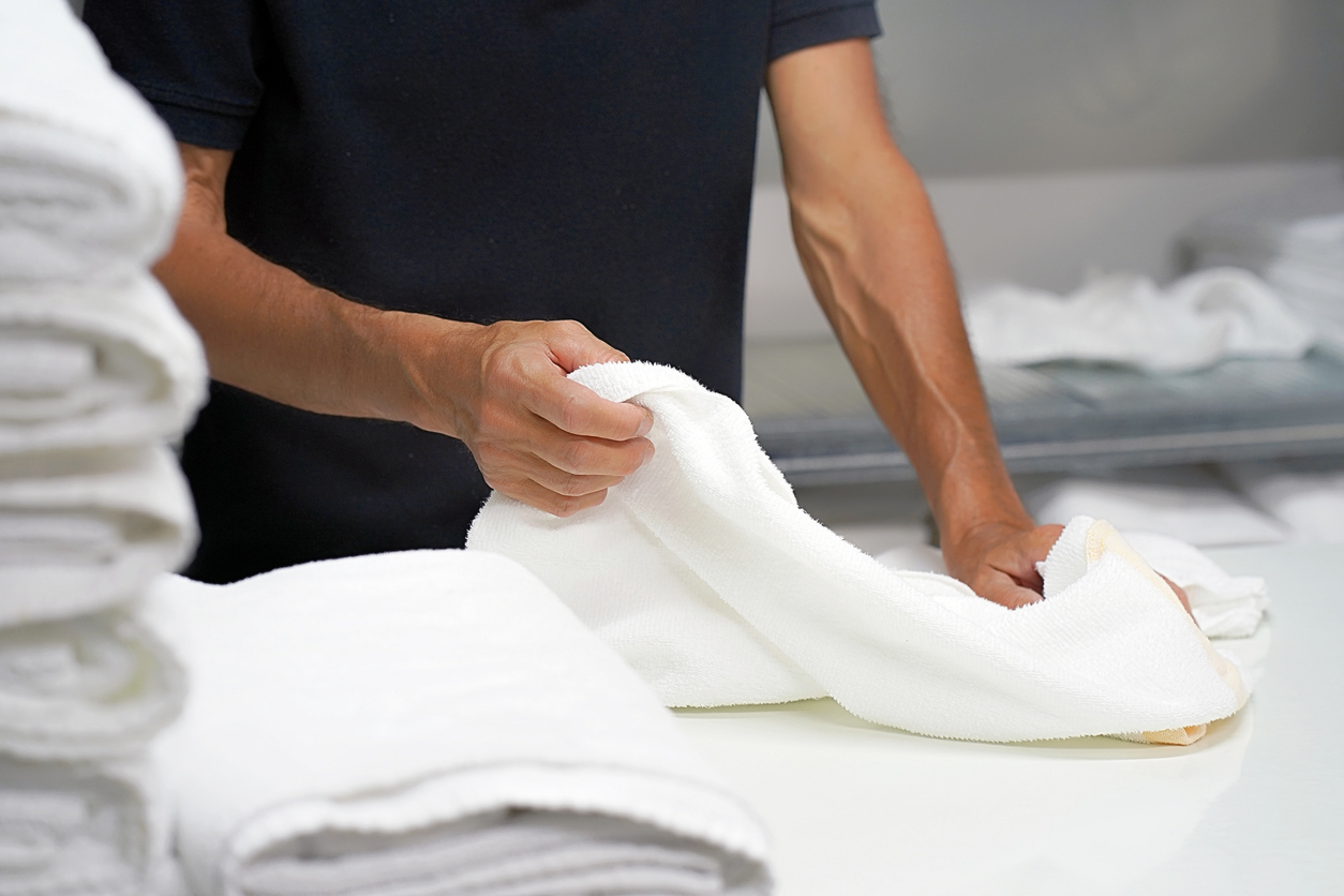 Man folds towel